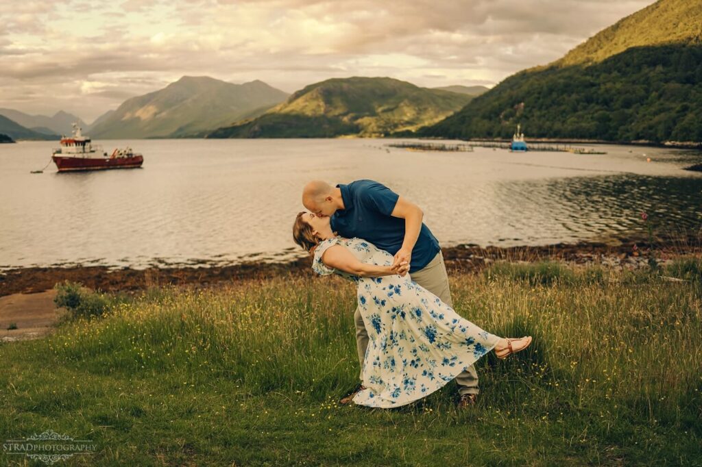 Couple embracing by scenic waterfront.