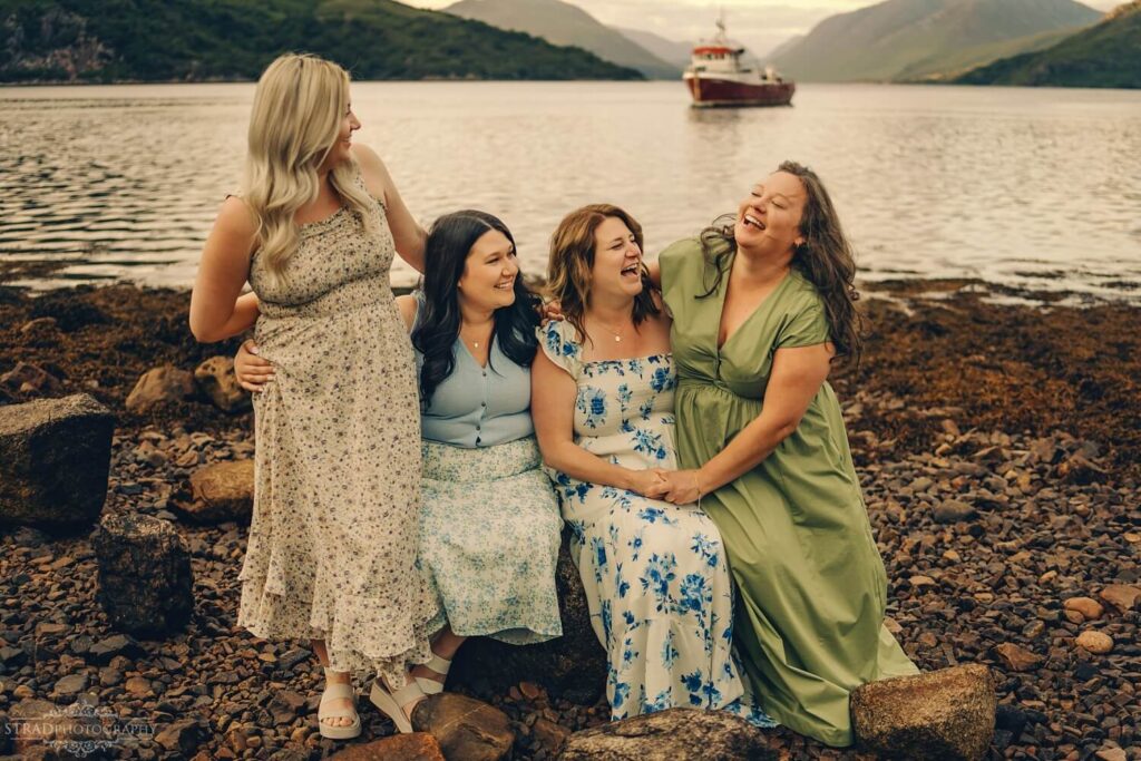 Four sisters laughing together on the rocks near Loch Etive