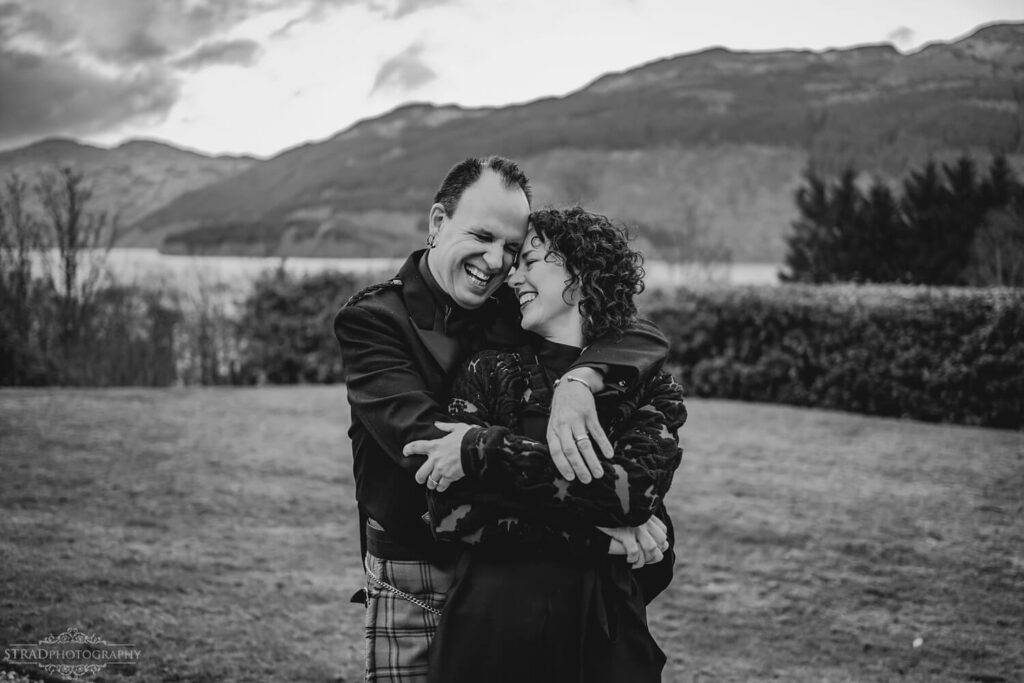 Couple embracing in scenic landscape.