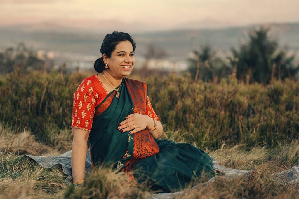 Pregnant woman in traditional attire outdoors.