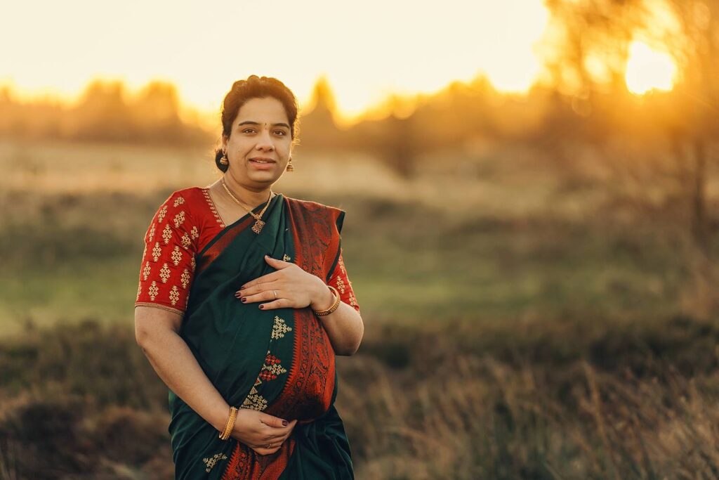 Pregnant woman in traditional attire outdoors.